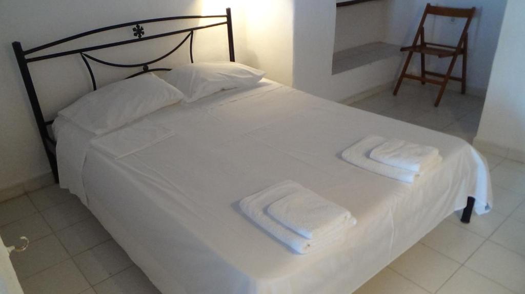 アンドロスにあるNeoclassical apartment, Central Chora Androsのベッドルーム1室(白いベッド1台、タオル2枚付)