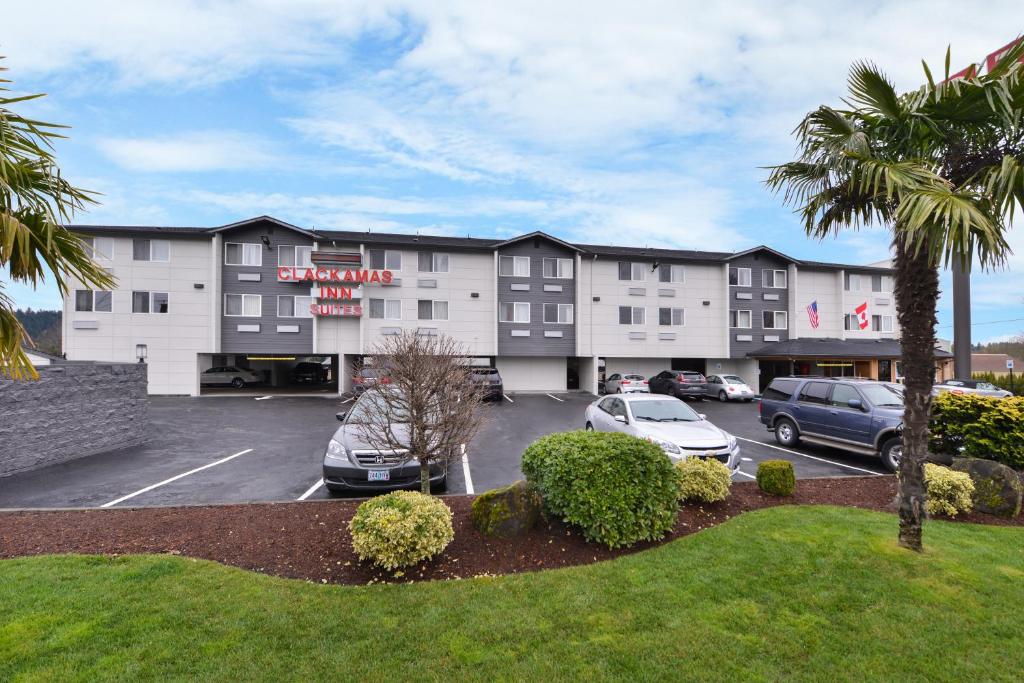 a hotel with cars parked in a parking lot at Clackamas Inn and Suites in Clackamas