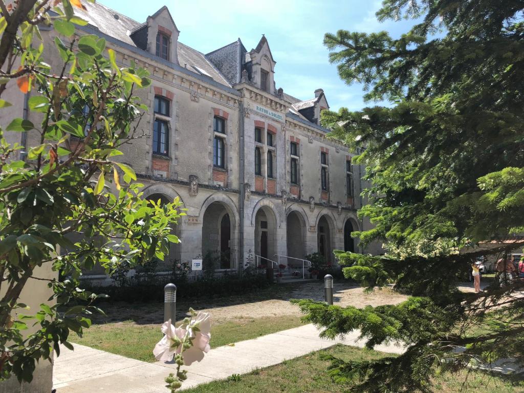 an old building with trees in front of it at Le Rayon de Soleil in Châtelaillon-Plage