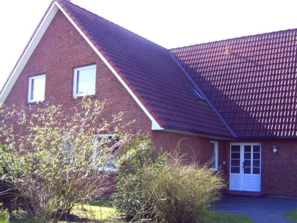 einem roten Backsteinhaus mit einem Gameradach in der Unterkunft Ferienwohnungen Walter in Cuxhaven