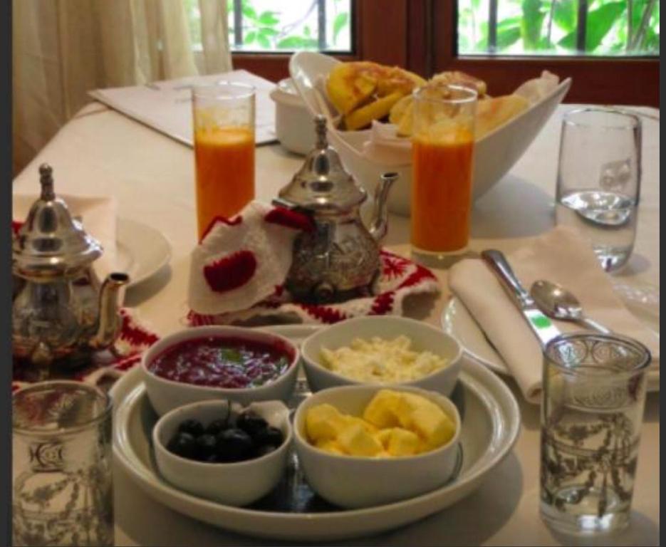 a table topped with dishes of food and drinks at Hotel Blanco Riad in Tetouan