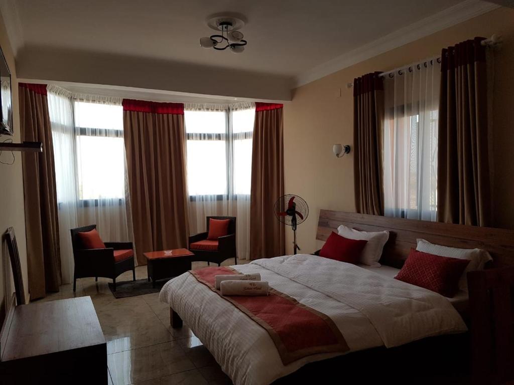 a bedroom with a large bed with red pillows at Select Hôtel in Morondava