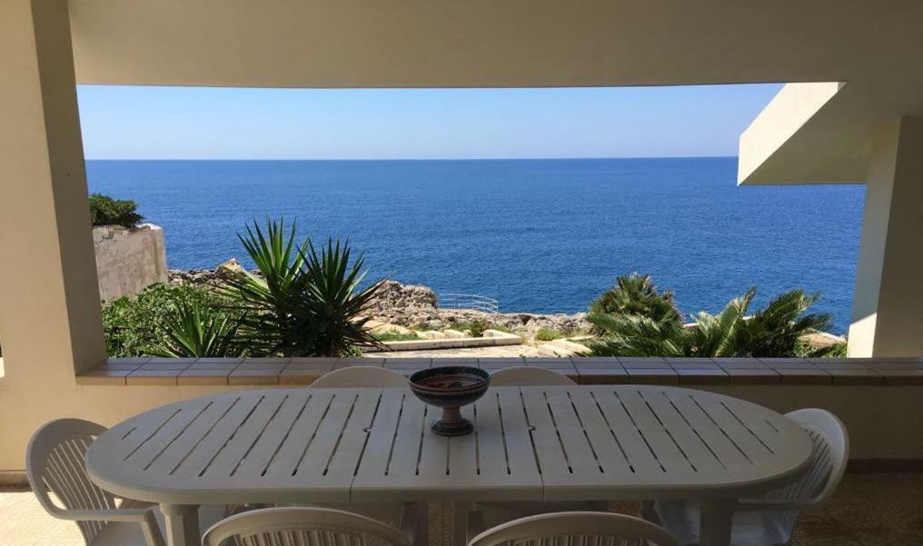 a table with chairs and a view of the ocean at Villa Linda on the sea in Siracusa