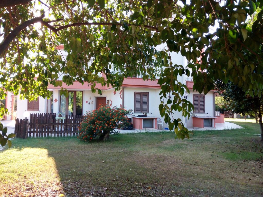 una casa rosa e bianca con una recinzione di B&B Leonida a Taranto