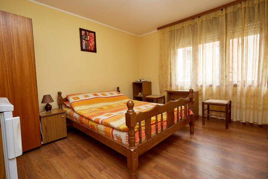 a bedroom with a bed and a window at Apartmani Malica in Soko Banja