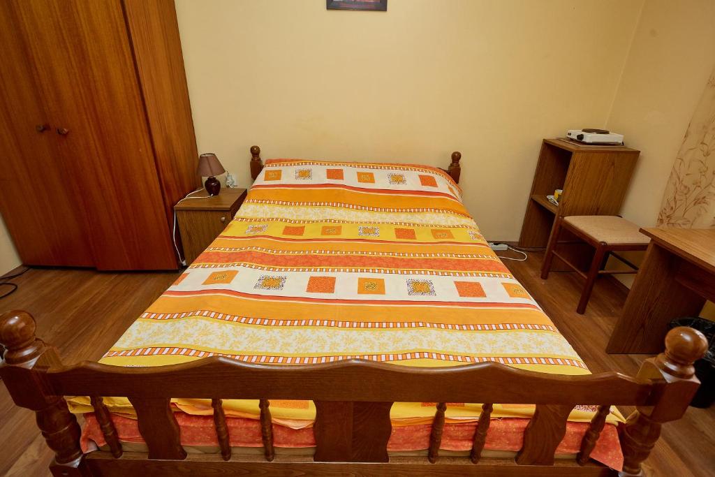 a bed with a quilt on it in a room at Apartmani Malica in Soko Banja