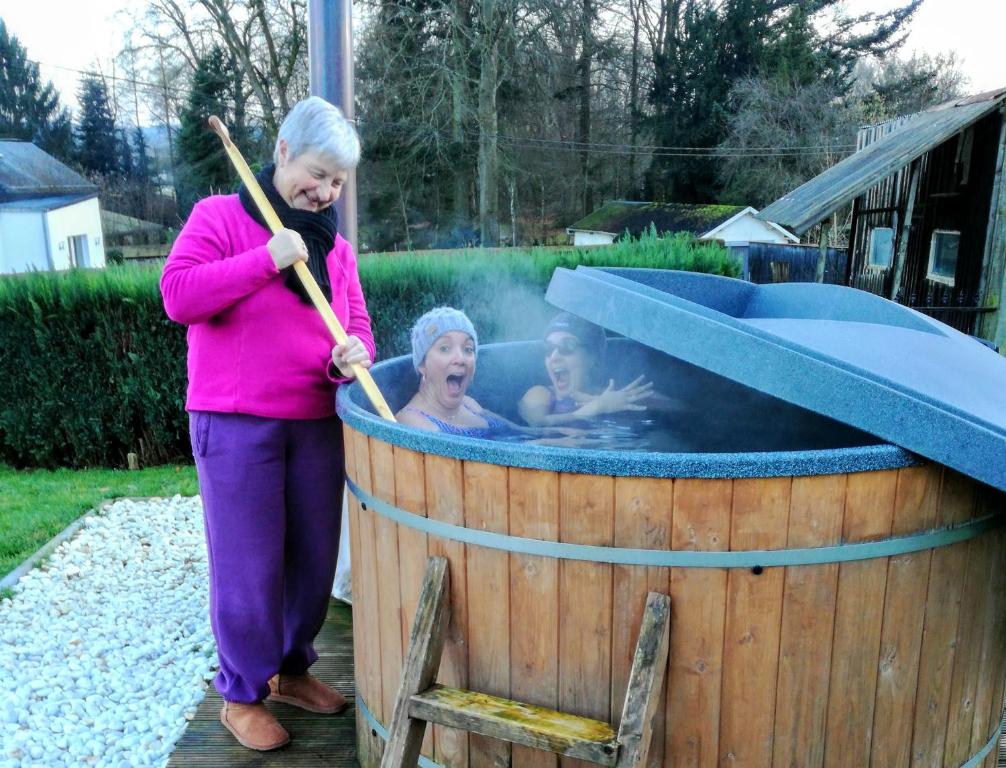 a woman with two girls in a hot tub at The BlackSmith's House in Libin