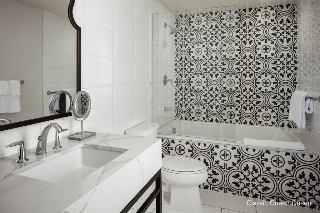 a white bathroom with a toilet and a shower at La Valencia Hotel in San Diego