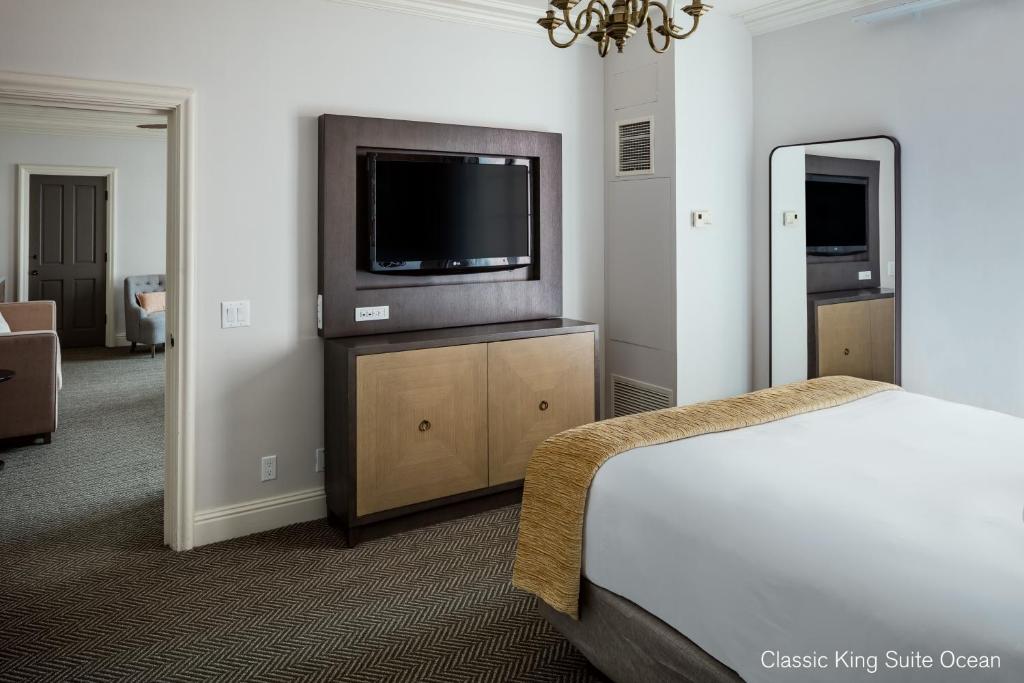 a bedroom with a bed and a flat screen tv at La Valencia Hotel in San Diego
