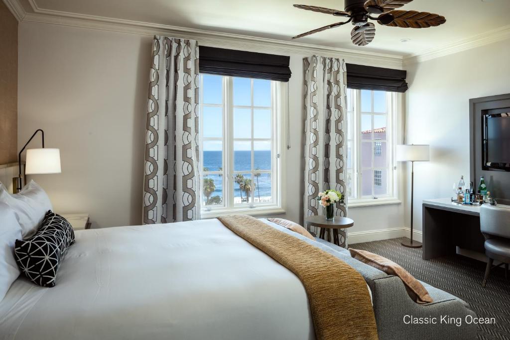 a bedroom with a large bed with a large window at La Valencia Hotel in San Diego