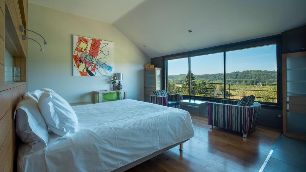 1 dormitorio con cama y ventana grande en Maison Anne Fouquet, en La Roque-Gageac