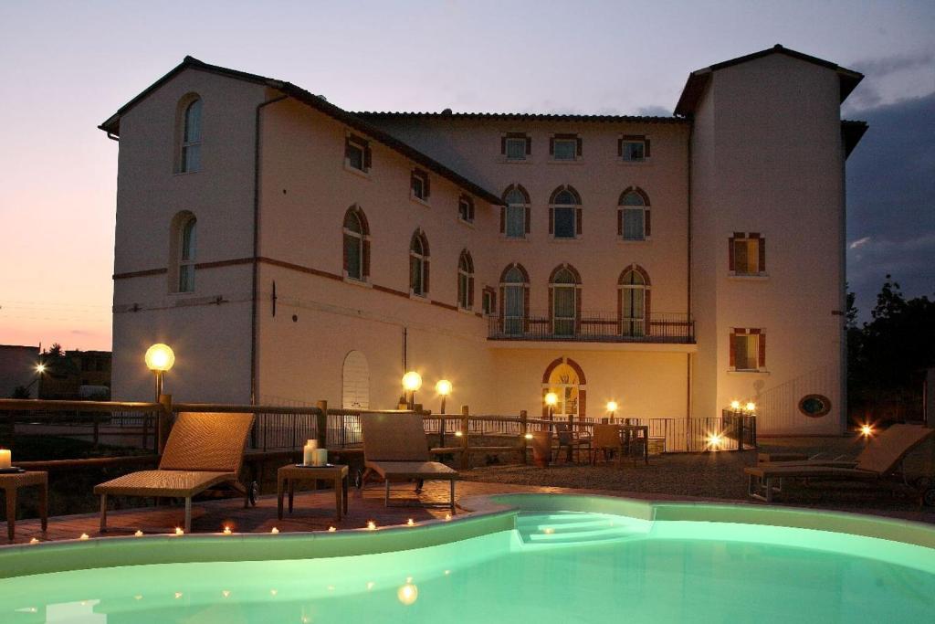 a large building with a pool in front of it at LHP Hotel Certaldo in Certaldo