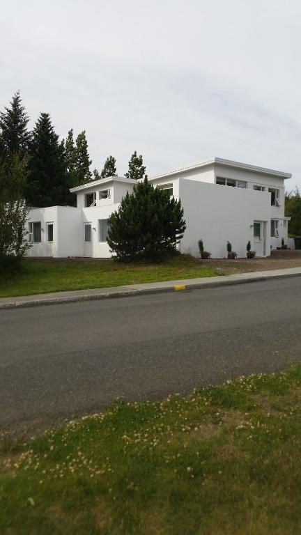 ein weißes Haus am Straßenrand in der Unterkunft Lagarfell Studios in Egilsstaðir