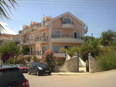 a large building with cars parked in front of it at Hellenic Sun in Lassi