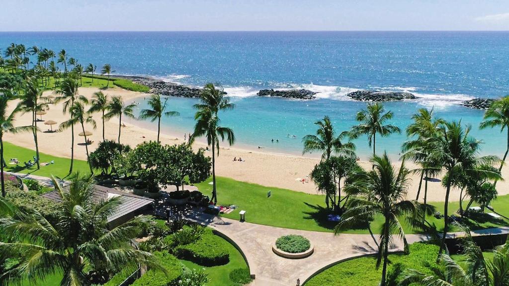 a view of a beach with palm trees and the ocean at Beach Villa at Ko'Olina in Kapolei