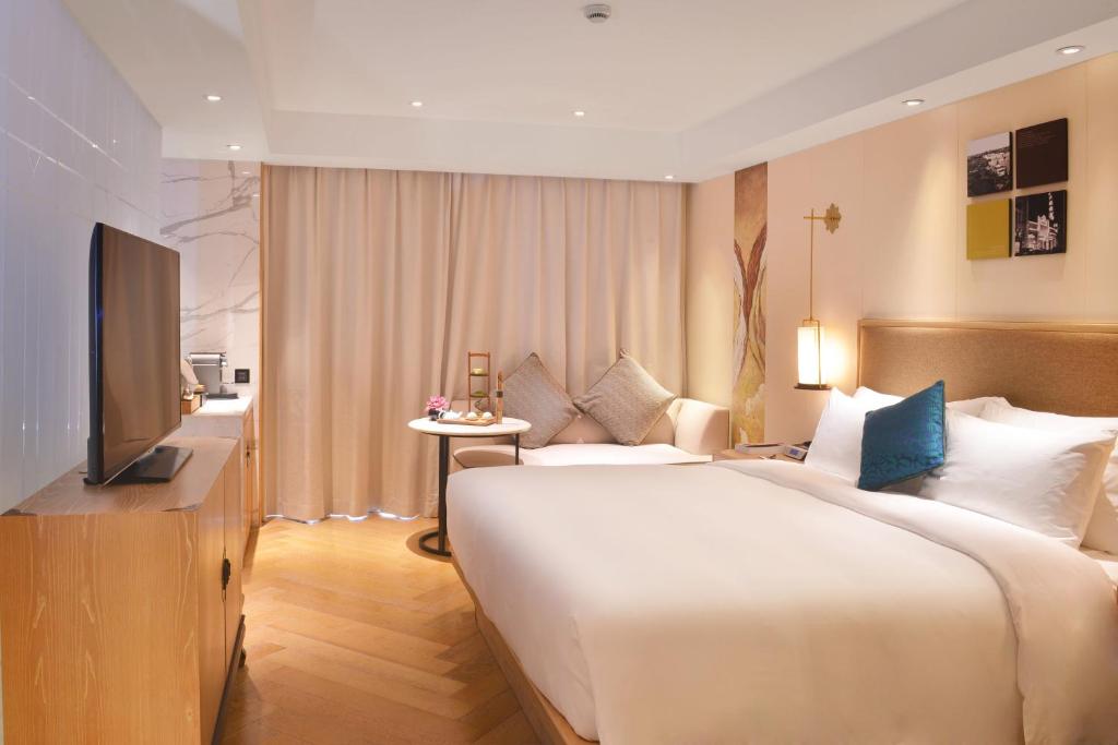 um quarto de hotel com uma cama grande e uma televisão em LN Hotel Five em Guangzhou
