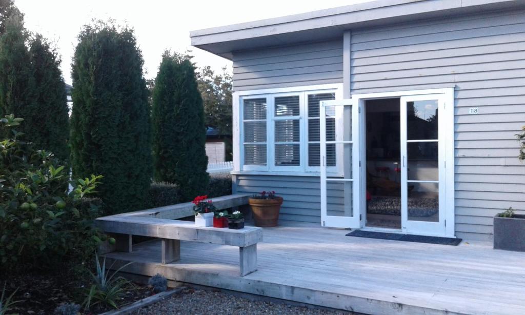 une terrasse couverte avec un banc à côté d'une maison dans l'établissement Peachgrove, à Hamilton