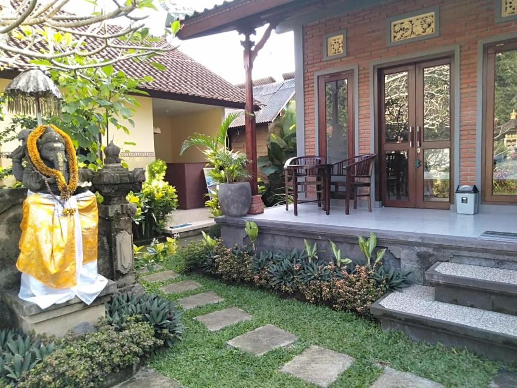 a house with a garden in front of it at Pondok Indah Homestay in Sidemen