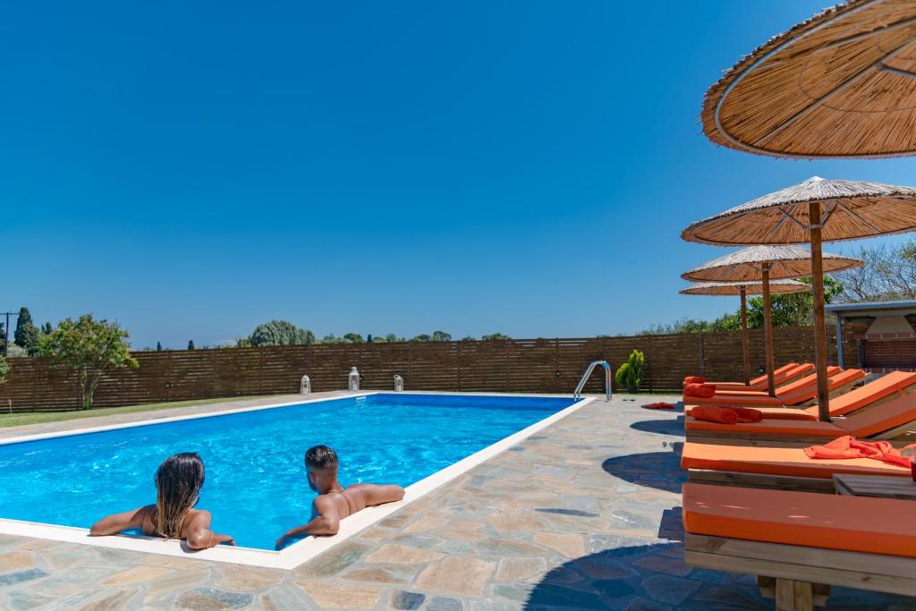 duas crianças estão sentadas numa piscina em Villa Antia em Metaxáta