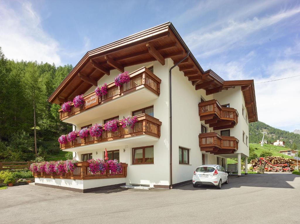 ein Gebäude mit Balkonen und Blumen darauf in der Unterkunft Appartement Gästehaus Bergkristall in Sölden