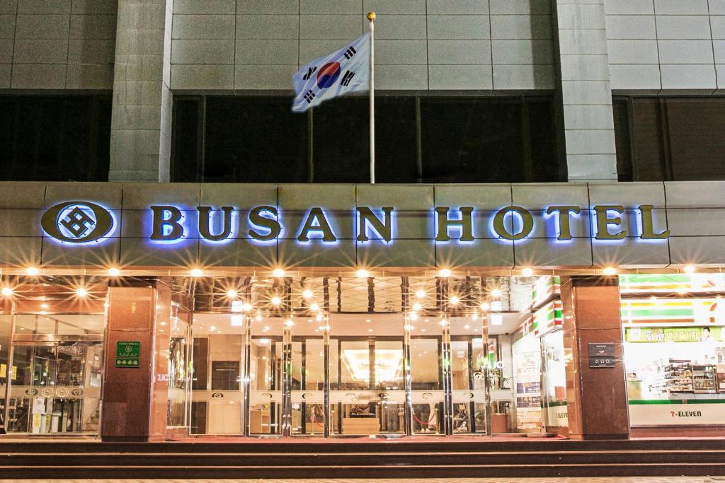ein Bushotel mit zwei Flaggen davor in der Unterkunft Busan Tourist Hotel in Busan