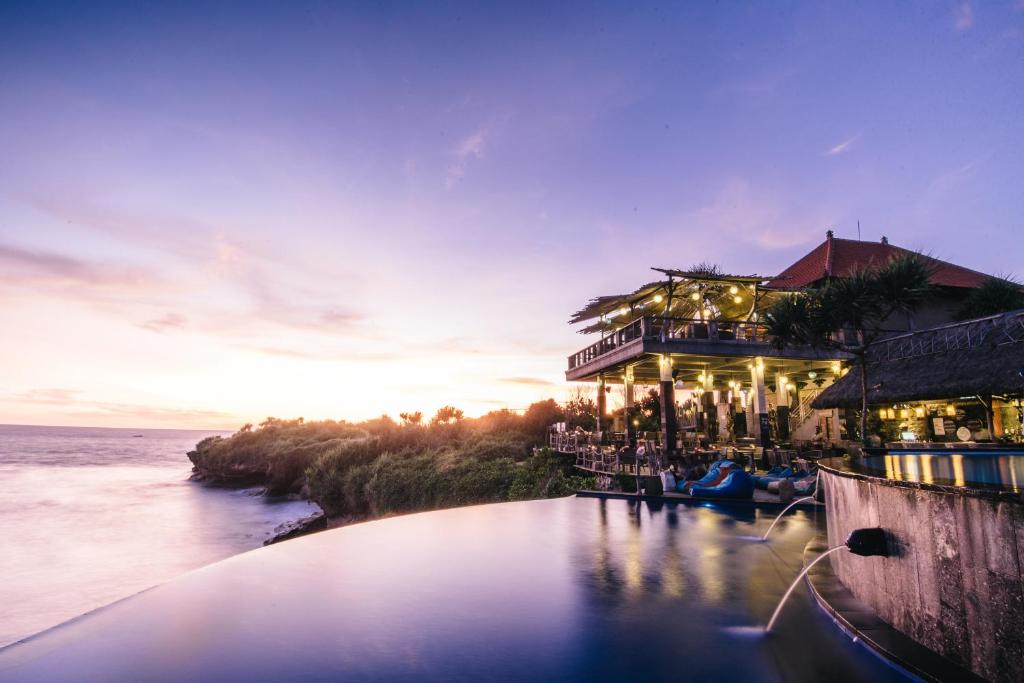 a resort with a pool in front of the water at Dream Beach Huts in Nusa Lembongan