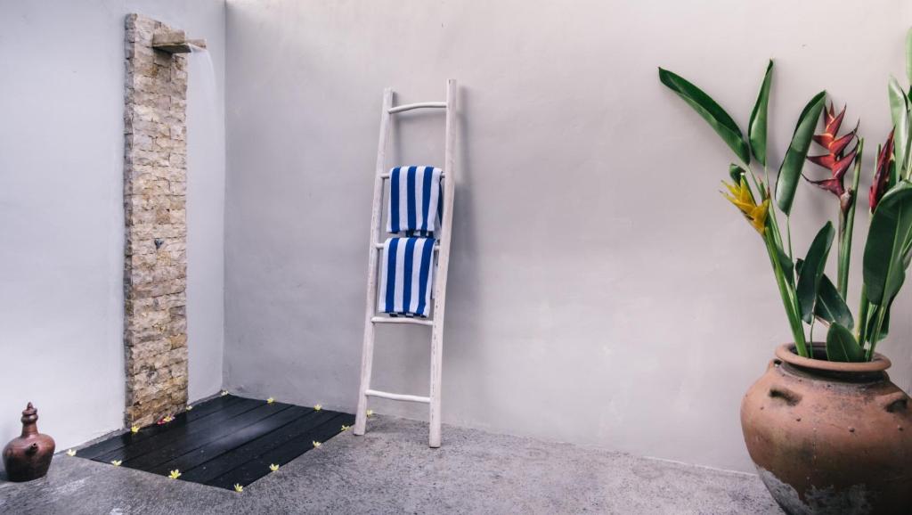 a ladder leaning against a wall next to a plant at Dream Beach Huts in Nusa Lembongan