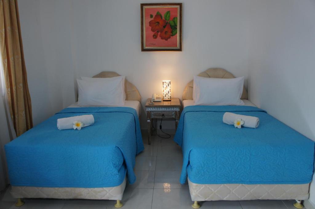 A bed or beds in a room at At The Beach Candidasa