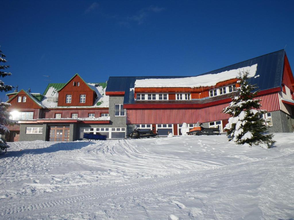 ein großes Gebäude im Schnee mit einem Weihnachtsbaum in der Unterkunft Horská chata Sedmidolí in Špindlerův Mlýn
