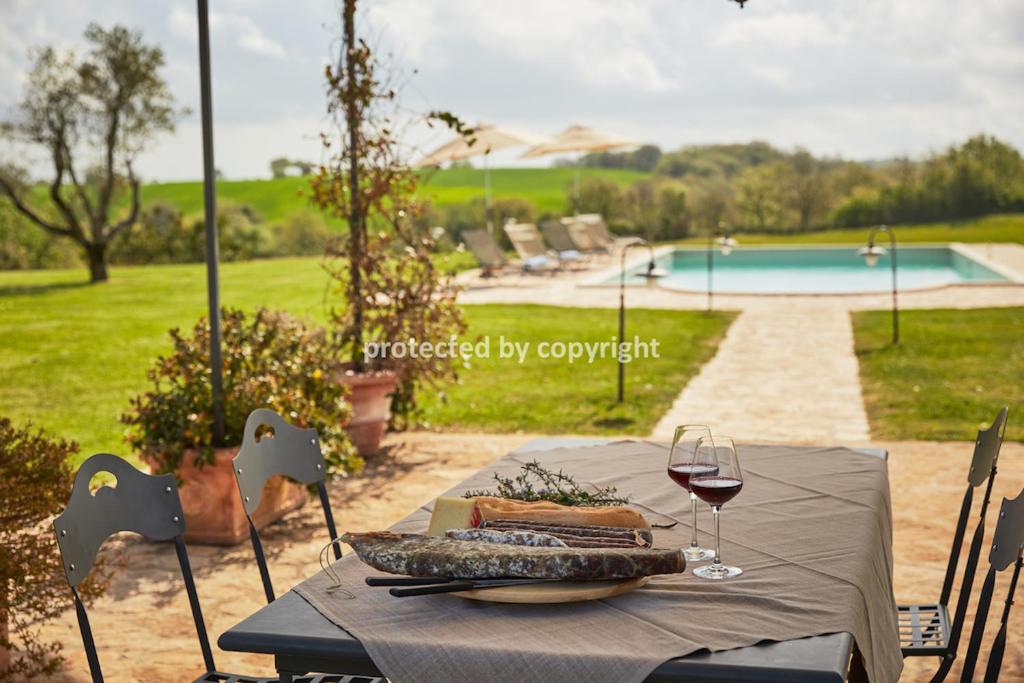 a table with a plate of food and a glass of wine at Lux Chic Villa near Pitigliano in Sorano