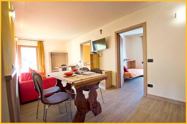 a room with a table and chairs and a bedroom at Mery Livigno in Livigno