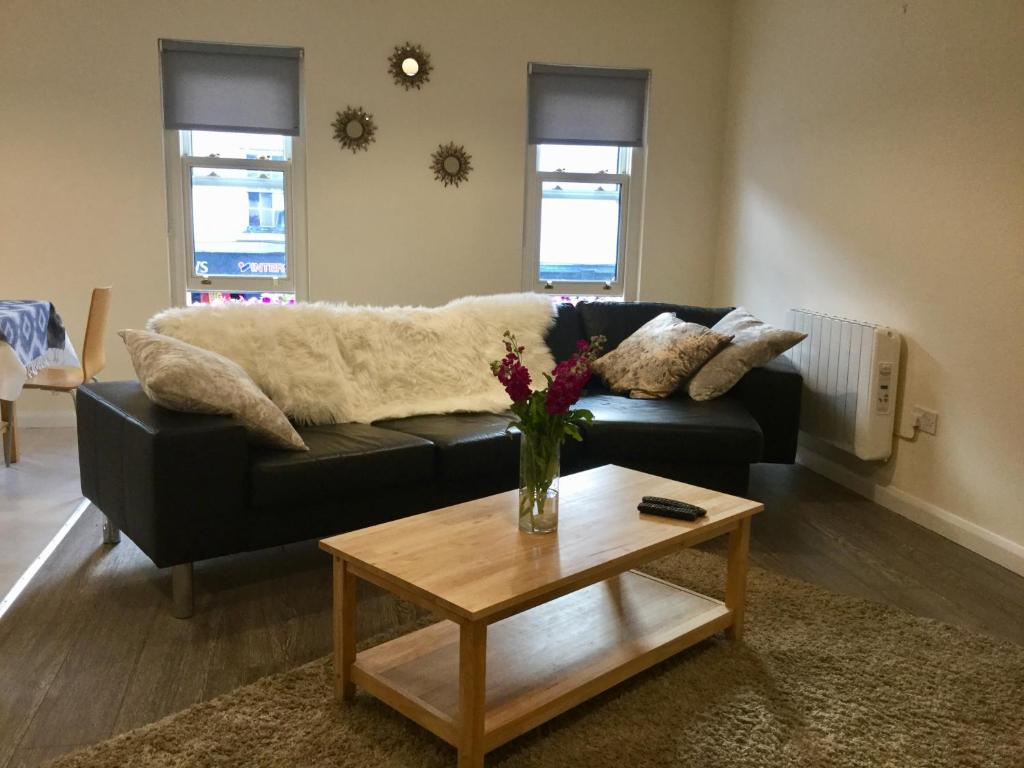 a living room with a black couch and a table at Rose Alley Apartment in Westport