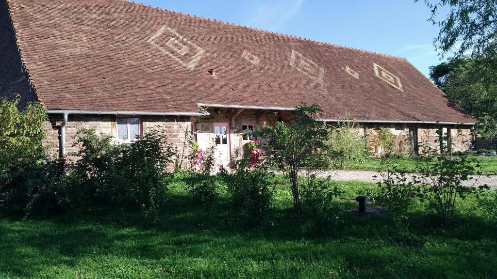 ein altes Steinhaus mit braunem Dach in der Unterkunft Chez les Goyp in Cosges