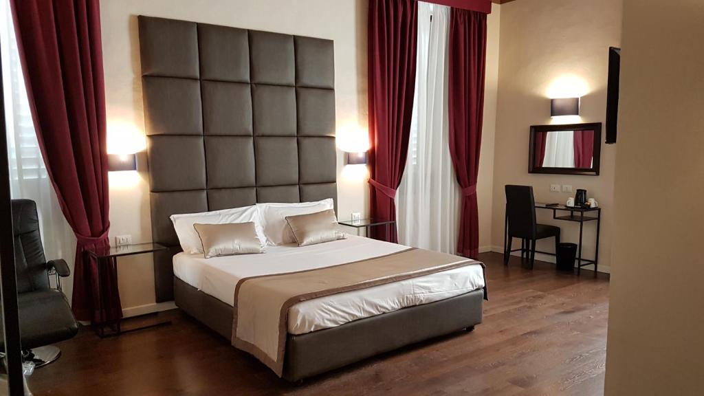 1 dormitorio con 1 cama grande y cortinas rojas en 1suite firenze, en Florencia