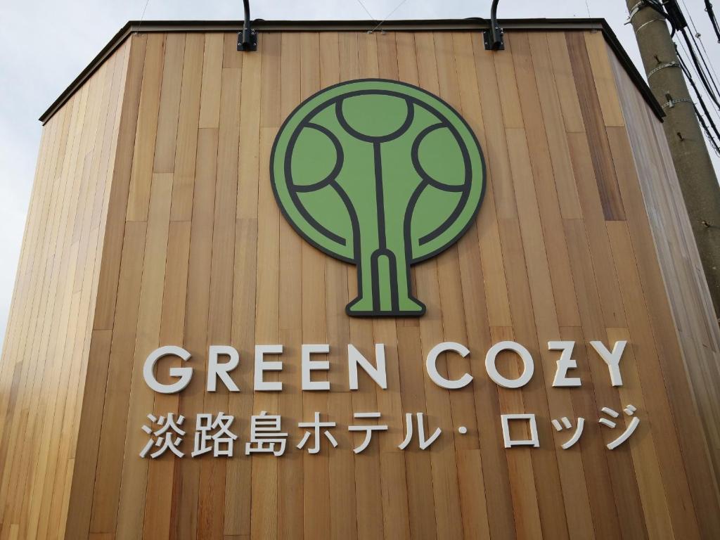 a green cork sign on the side of a building at Awajishima Hotel Lodge GREEN COZY in Minamiawaji