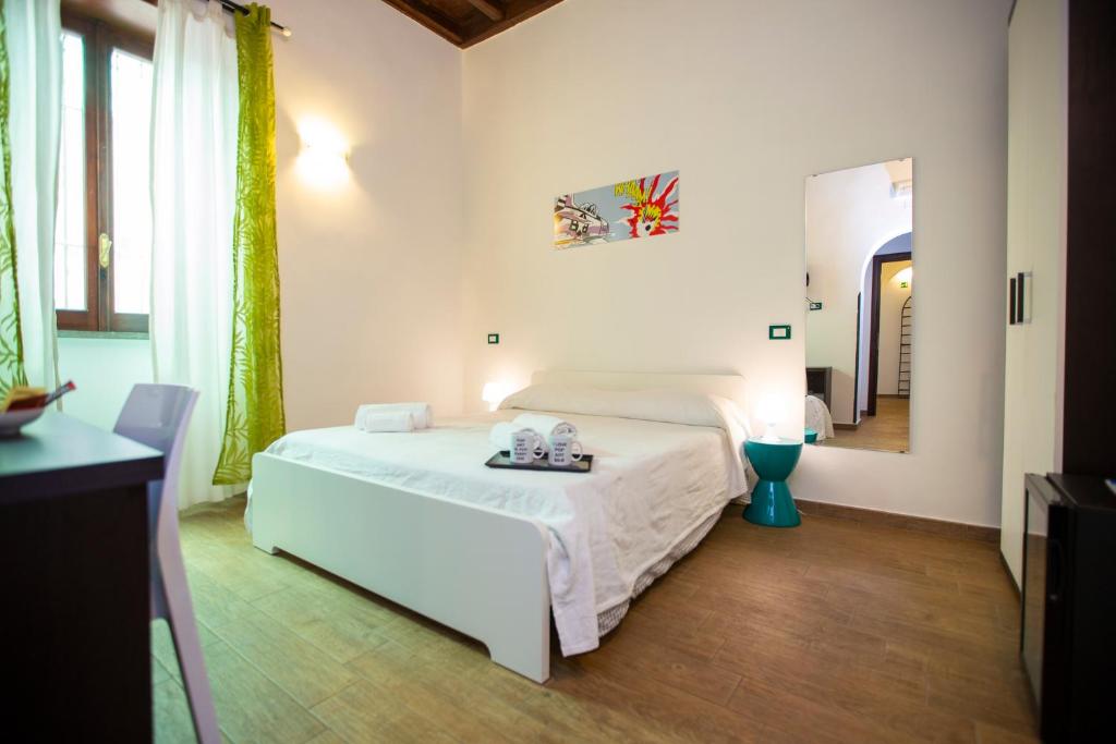 biała sypialnia z łóżkiem i lustrem w obiekcie POP Art B&B w Rzymie