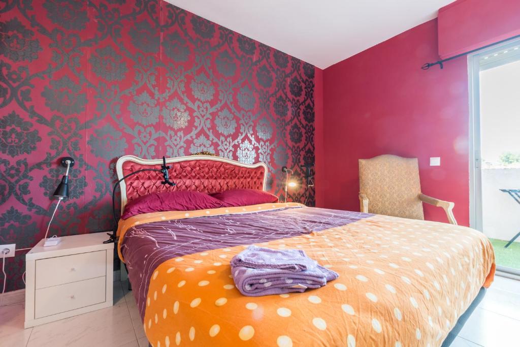 1 dormitorio con 1 cama con pared roja en Rooms Salomons by easyBNB, en Alcalá de Henares