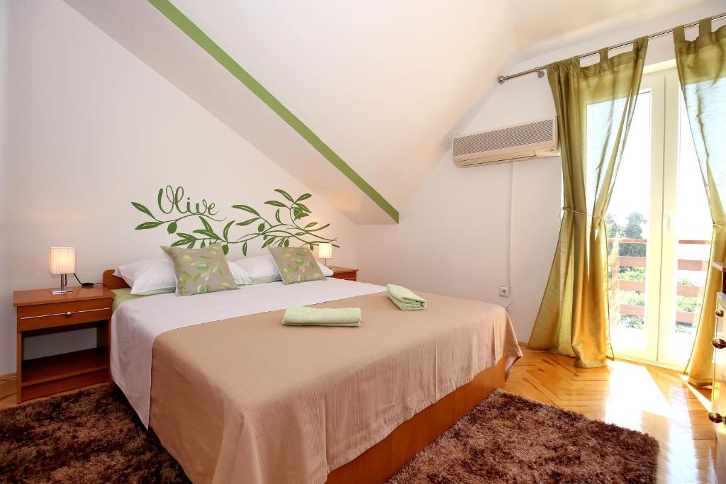 ein Schlafzimmer mit einem Bett und einem großen Fenster in der Unterkunft Apartments Mara in Zadar