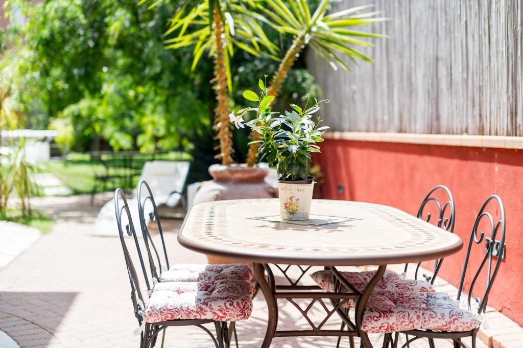a table and chairs with a potted plant on a patio at Villa Lisa in Diano Marina