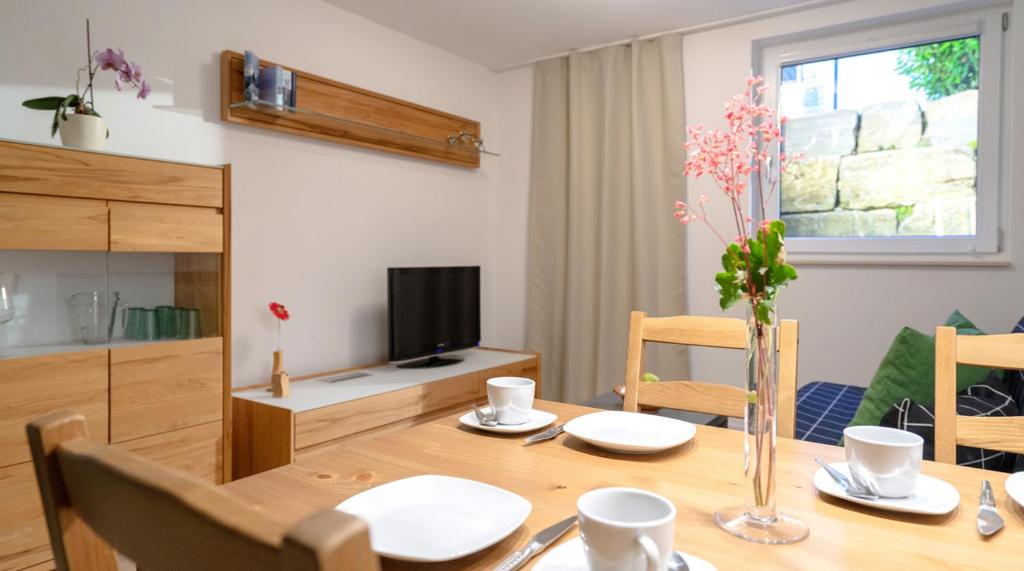 a dining room with a table and a television at Ferienwohnung Mittelsberg in Konstanz