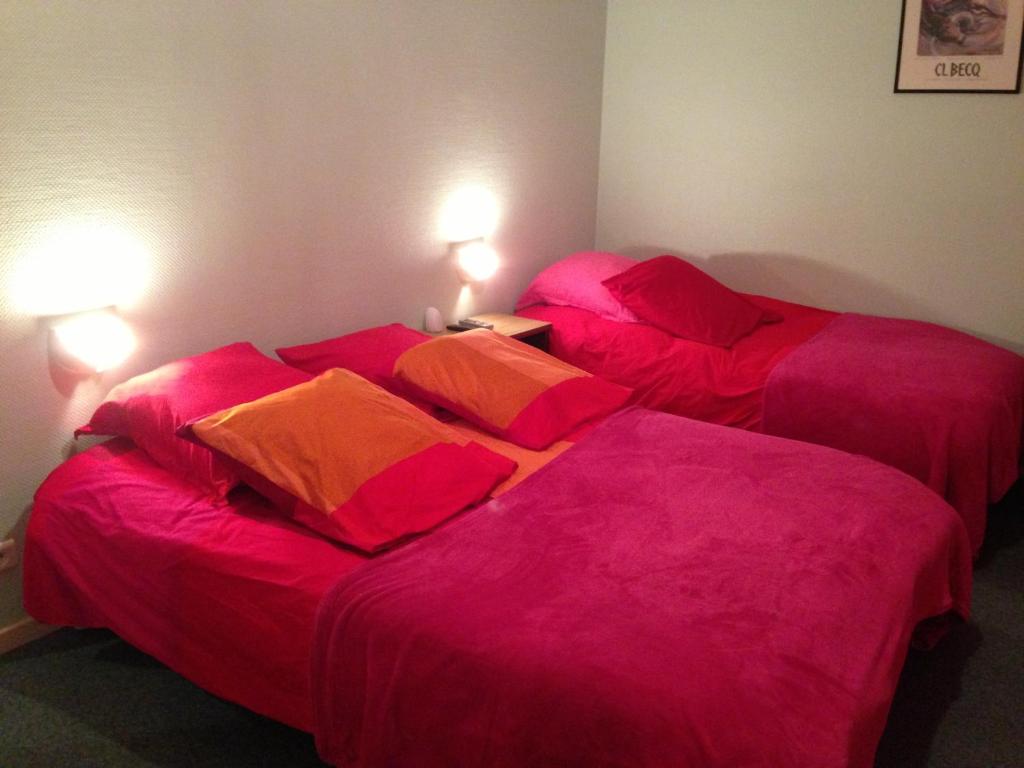 Marville的住宿－貝萊爾酒店，配有粉红色床单和枕头的客房内的两张床