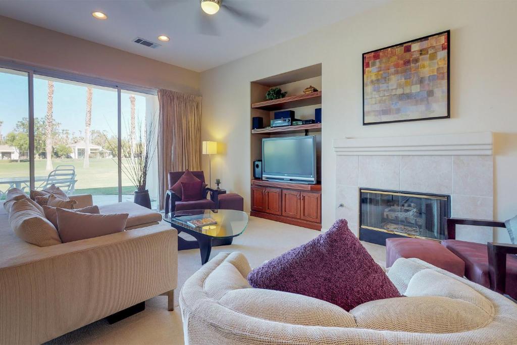 sala de estar con sofá y chimenea en Tanglewood Terrace en La Quinta