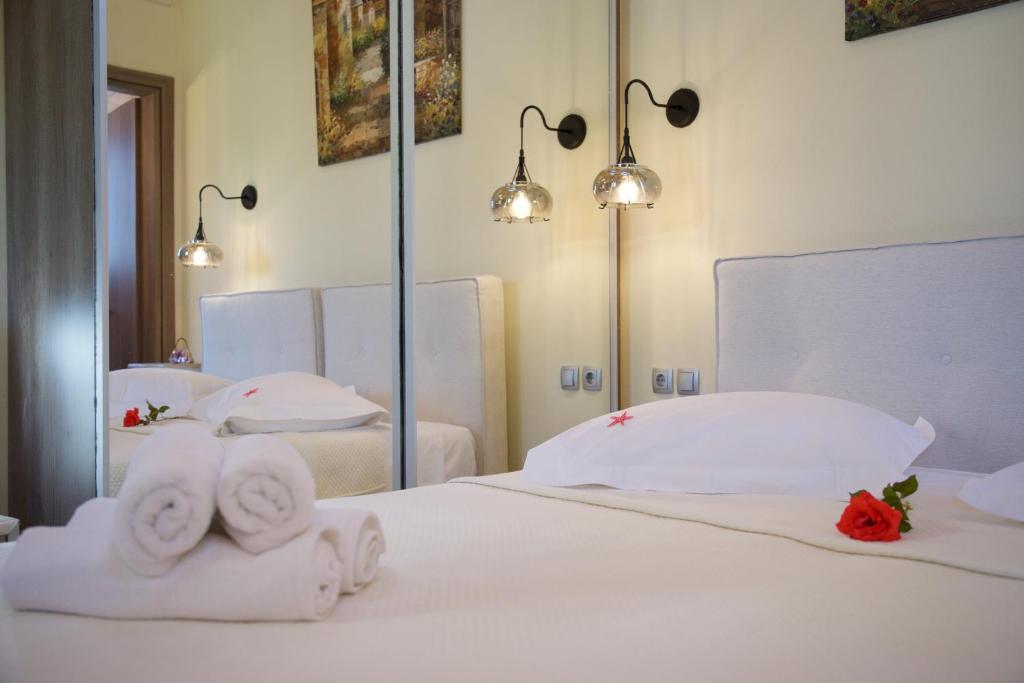 sypialnia z 2 łóżkami, ręcznikami i lustrem w obiekcie Villa Rospovi w mieście Kaligata