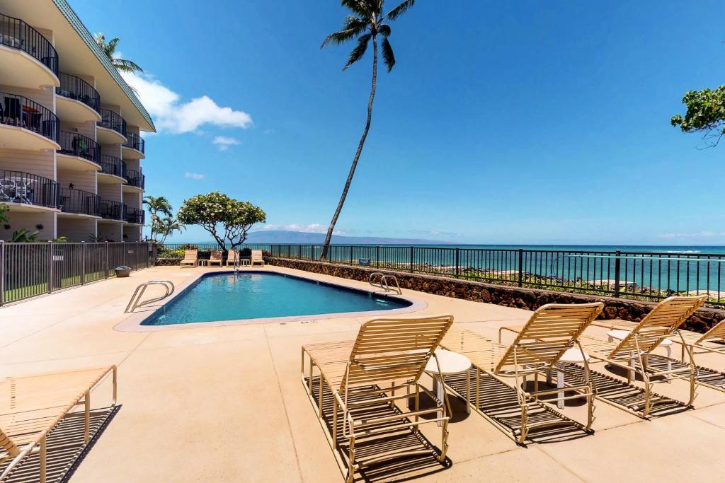 a group of chairs sitting around a swimming pool at Kahana Reef Oceanfront Condos in Kahana