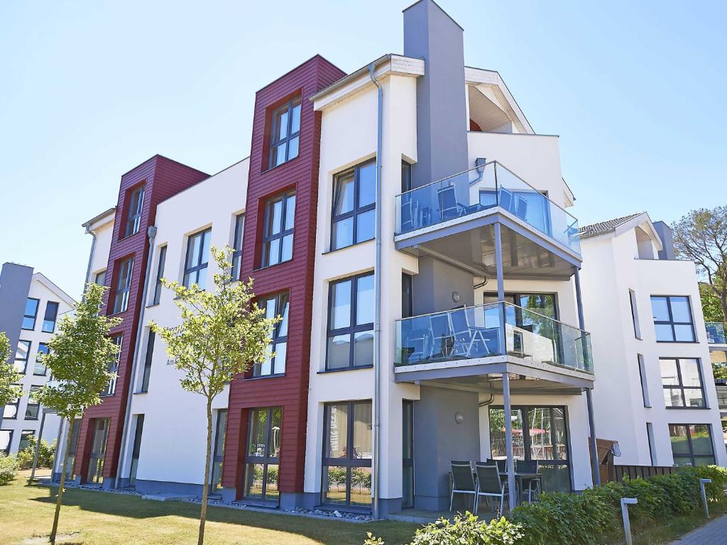 an apartment building with a balcony on a street at Strandvilla Baabe F 635 WG 26 mit Meerblick, Kamin, Sauna, Whirlpool in Baabe