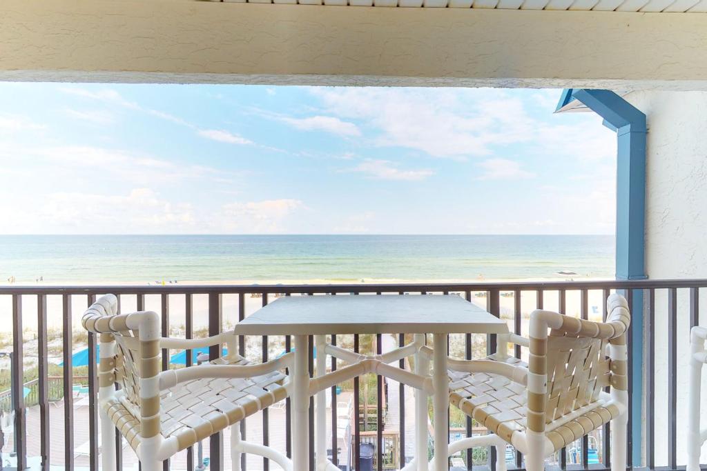 a balcony with a table and two chairs and the ocean at The Whispering Seas in Panama City Beach