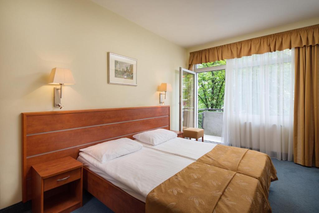 Un dormitorio con una cama grande y una ventana. en Benczur Hotel, en Budapest