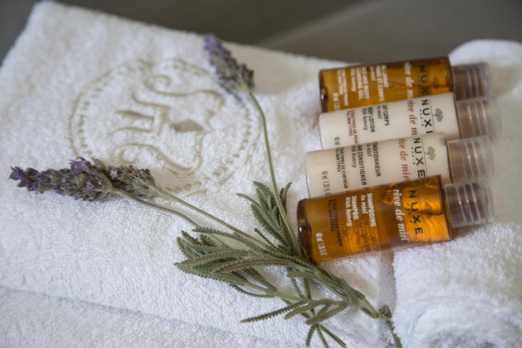 two tubes ofodorizers sitting on a white towel at Poseidon of Paros Hotel & Spa in Chrissi Akti
