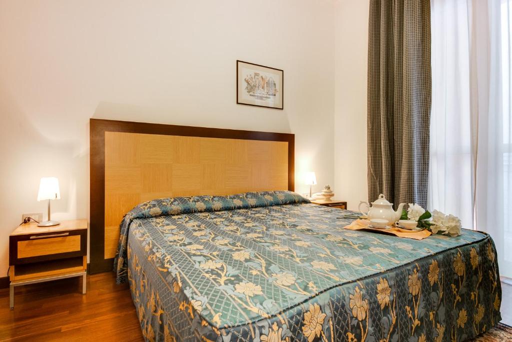 a bedroom with a bed with a blue comforter at Aris Hotel in Bellaria-Igea Marina