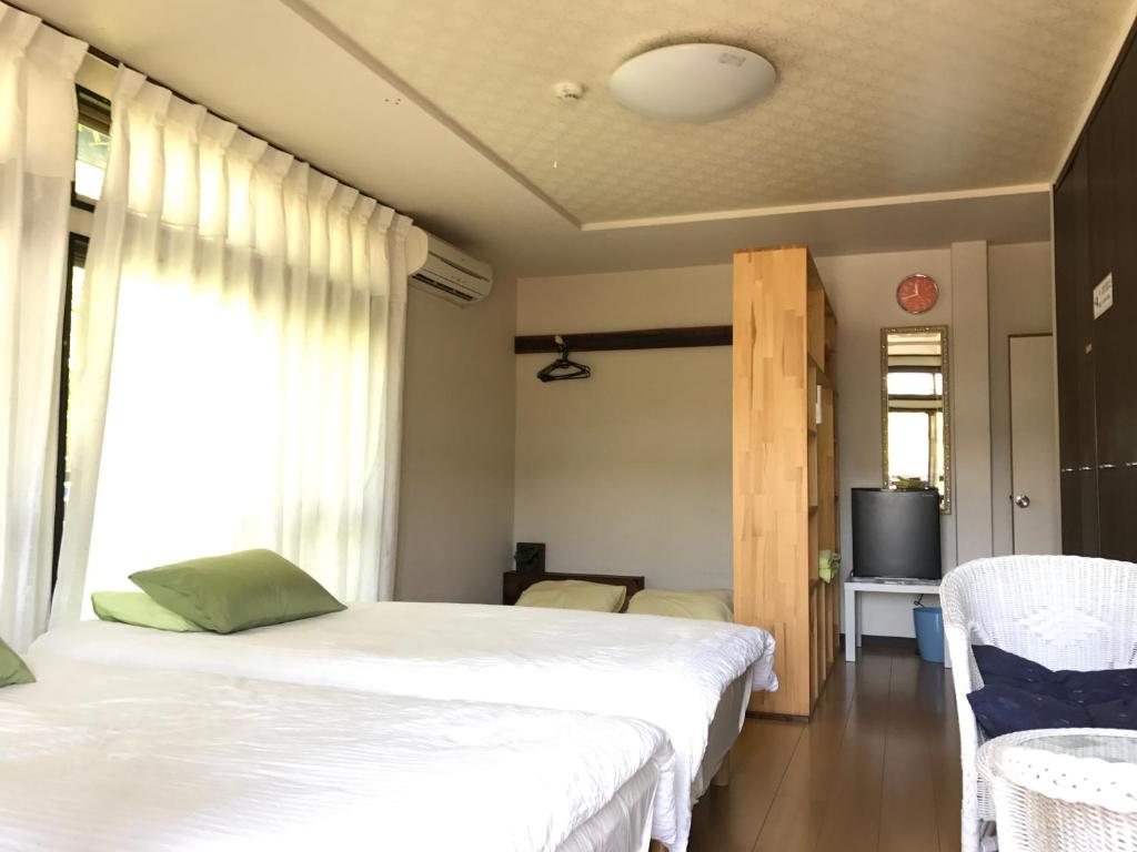 Postel nebo postele na pokoji v ubytování Guest House Hennka Kyoto